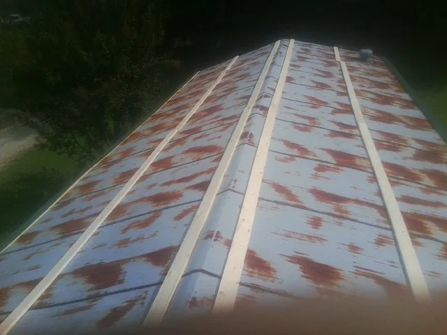 Rusted metal roof panels with new wood purlins before replacement — Storm Damage Roof Repair in Townville by Roofing Brothers