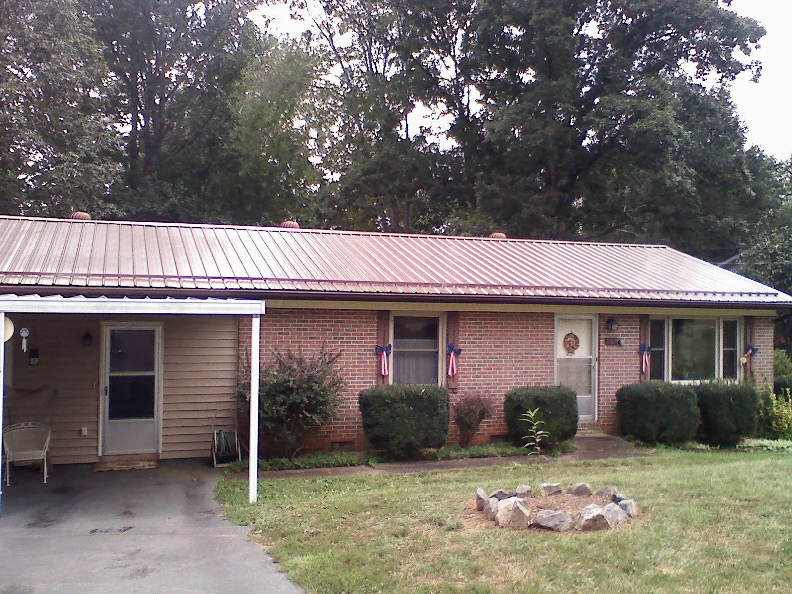 Bronze metal roof and carport on a brick ranch home — Roof Repair work by our crew in Townville